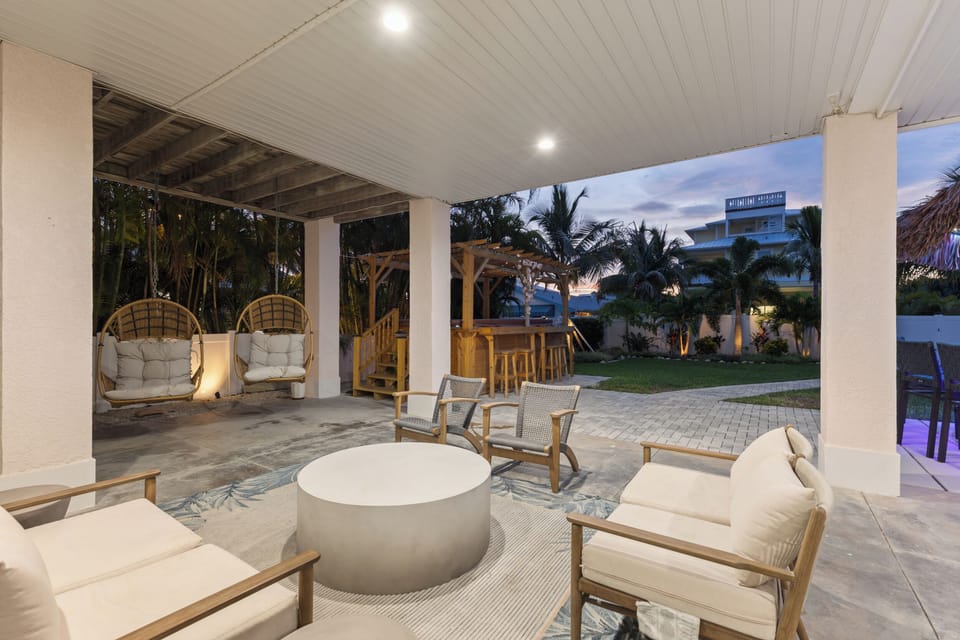 Unwind in your private covered patio with swinging egg chairs and tropical views—perfect for evening conversations under the palms.