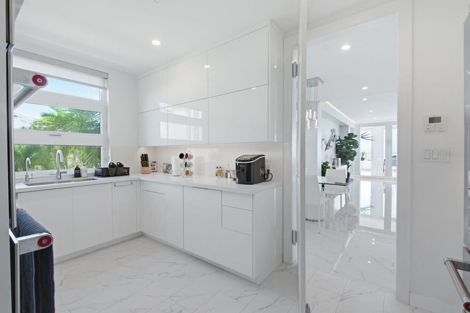 Cook with a View: A bright, modern kitchen workspace overlooking lush tropical greenery and open to the main living areas.