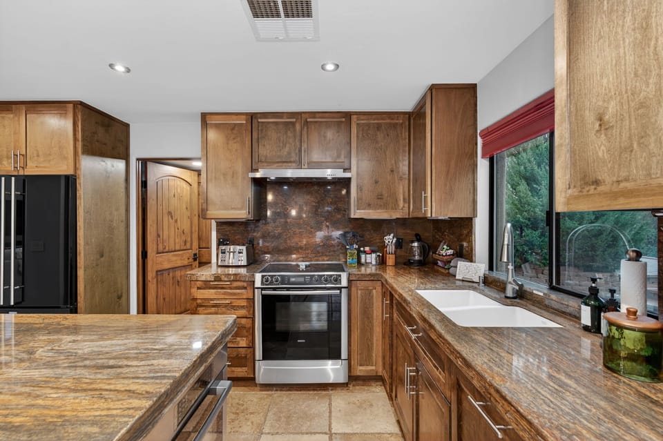Stainless steel appliances, stone counters, forest views and everything for the chef in your group.