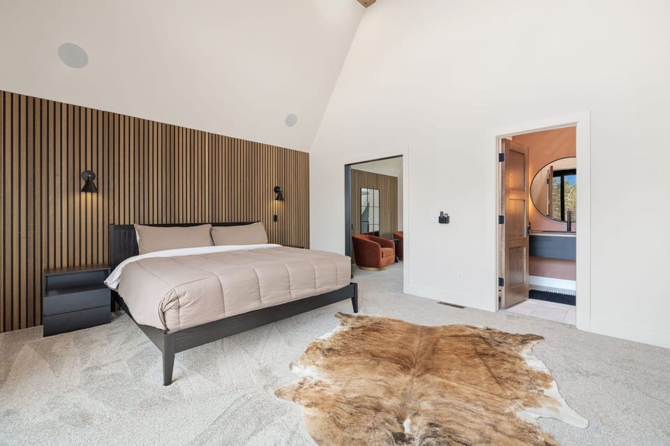 In the loft is our primary bedroom - it is complete with a King-size bed, Smart TV, access to a private balcony, and en suite bathroom with a luxurious shower.