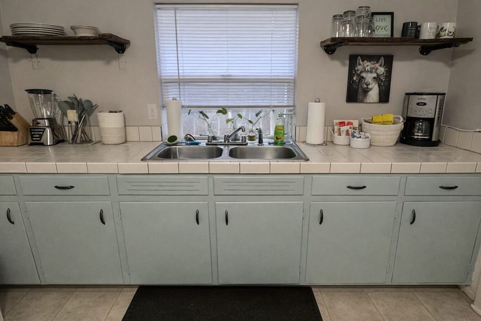Bright kitchen with double sink, open shelving, and ample storage for longer vis