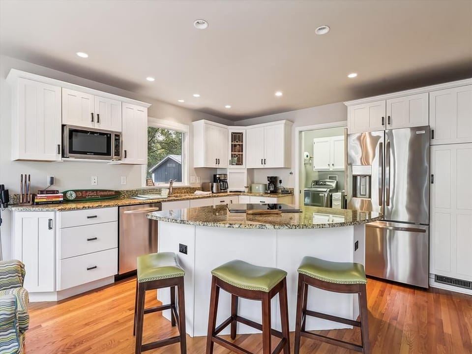 The modern kitchen, with its light-filled space and stylish cabinetry, offers a cozy gathering place for family meals and culinary creativity in a serene coastal setting.