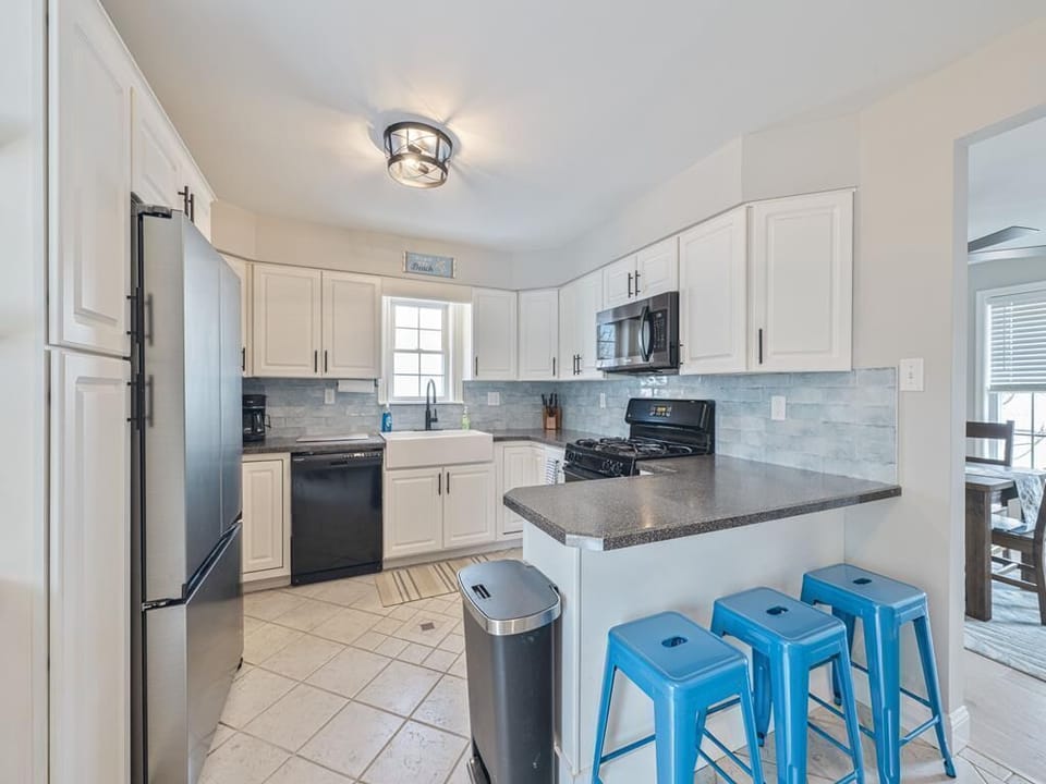 With sleek cabinets and ample counter space, this kitchen is a chef's paradise adorned in coastal hues.