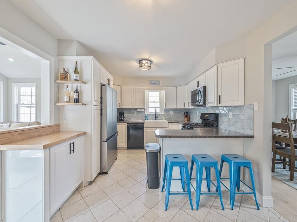 This inviting kitchen showcases stainless steel appliances and a cozy breakfast bar, perfect for casual dining.