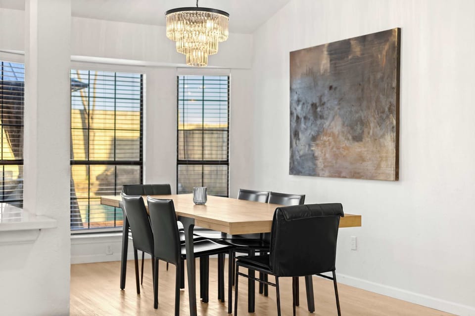 Stylish dining area with elegant chandelier and seating for six—perfect for shared meals, game nights, or gathering with friends and family.