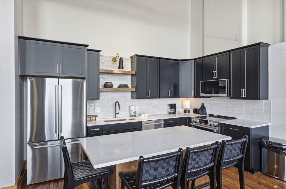 Custom cabinetry, quartz counters, and polished stainless appliances create a kitchen that feels equal parts functional and refined.