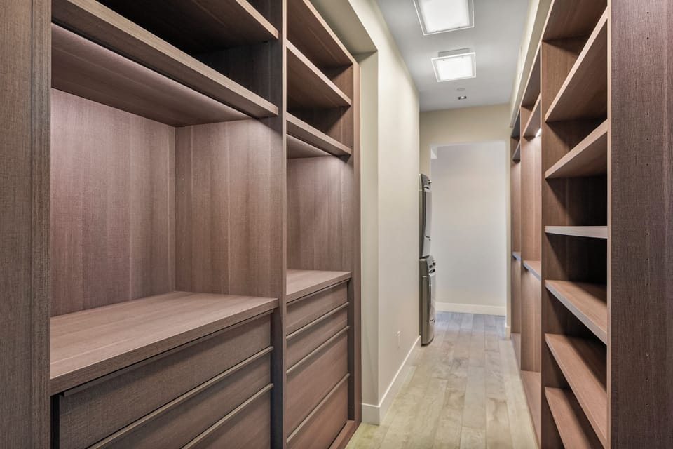 Your spacious walk-in closet features rich wood shelving and drawers, providing ample storage to keep your vacation wardrobe perfectly organized.