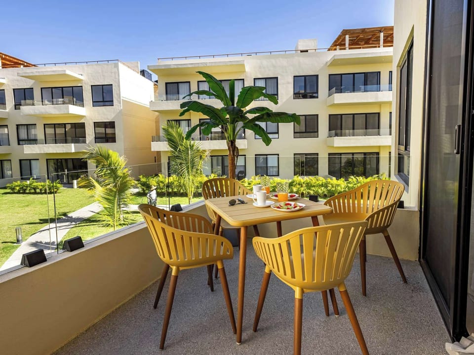 Private balcony w/ bistro seating overlooking the lush courtyard & swaying palms below