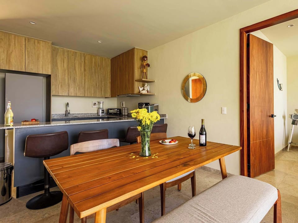 Warm dining area w/ wooden table set beside the kitchen for easy shared meals
