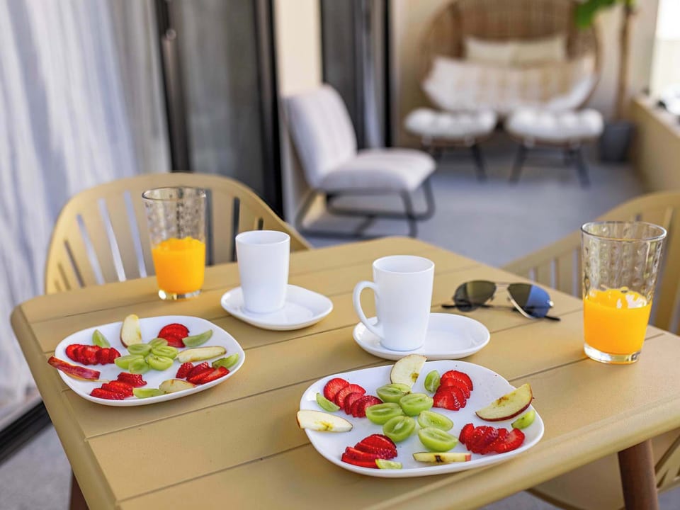 Sunny balcony breakfast setup w/ fresh fruit & coffee for a relaxed morning