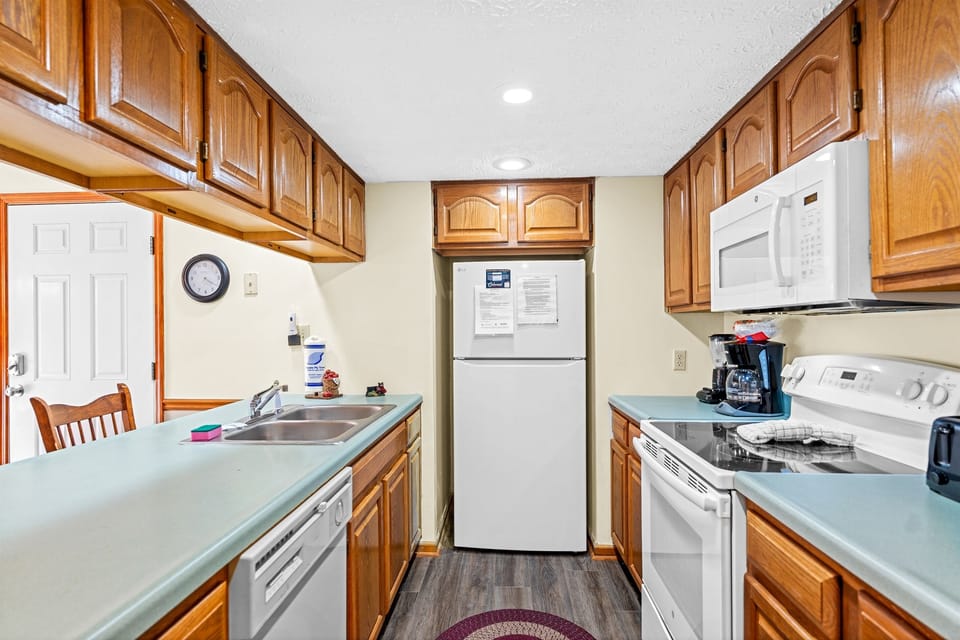 Fully equipped kitchen with full-size fridge, stove, microwave, dishwasher, and coffee maker—everything you need for quick breakfasts, easy dinners, or leftovers between shows, attractions, and dining just minutes away in Pigeon Forge.