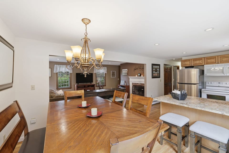 Bright dining space for 6 with natural light and a chandelier.