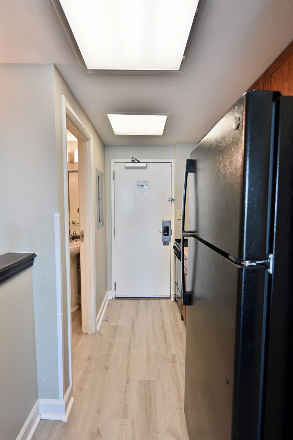 Entry hallway with full refrigerator and convenient storage space nearby