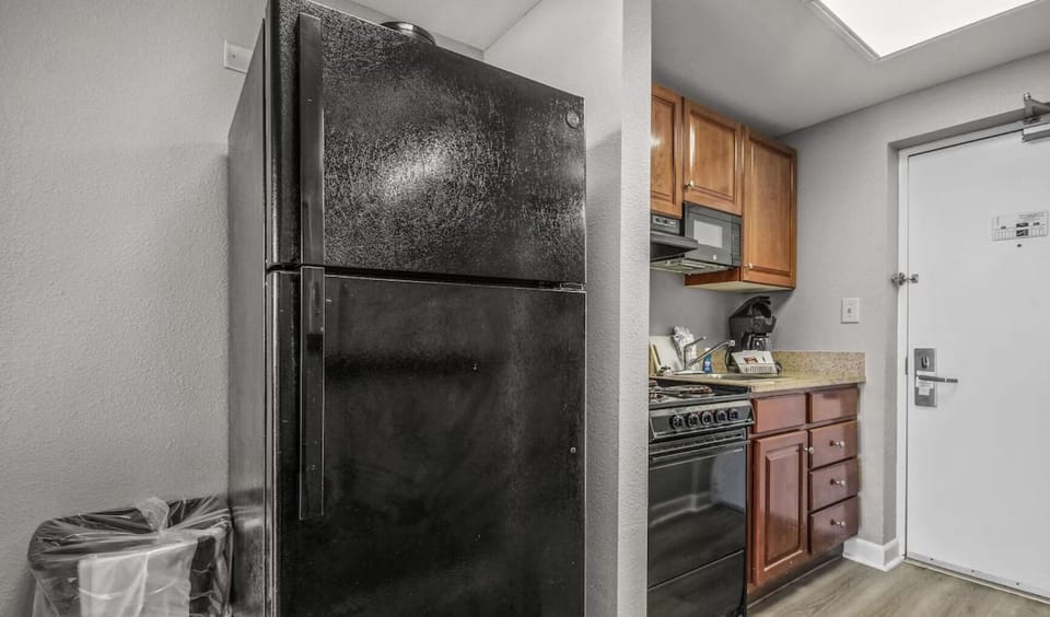 Features granite-style countertops, a stainless steel sink, and wood cabinetry.