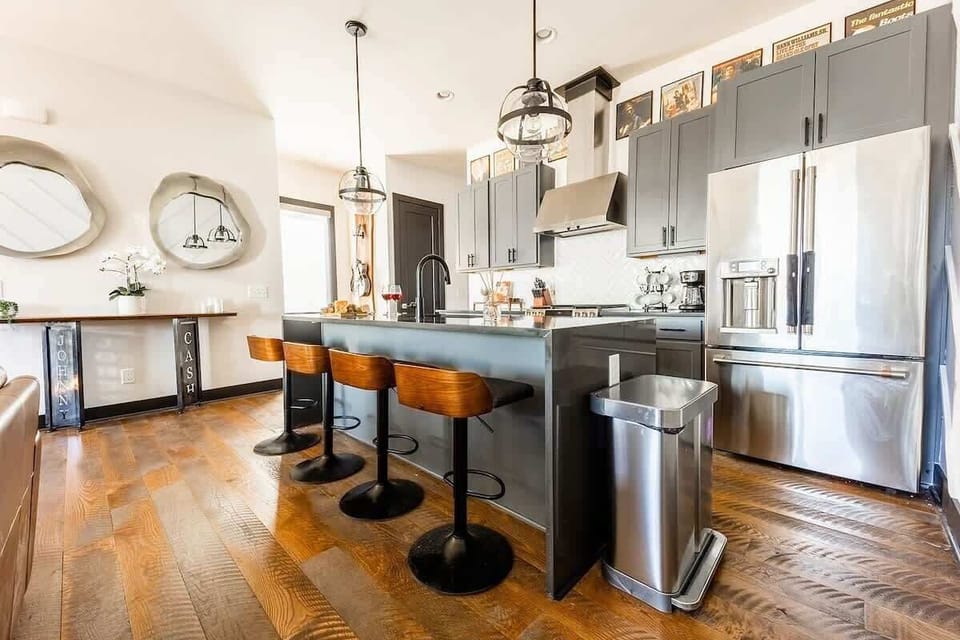 Unit 2 (2nd Floor): Fully equipped kitchen with stainless steel appliances, and breakfast bar seating with bar stools.
