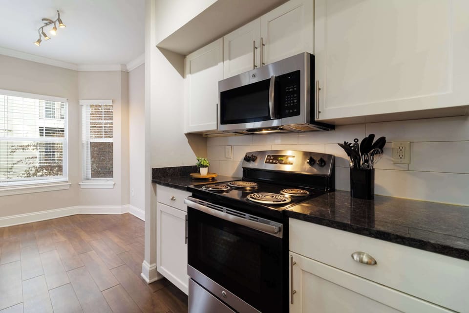 Modern gourmet kitchen featuring granite counters & full cooking setup.