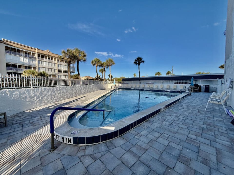 Relax poolside with palm trees and ocean air all around.