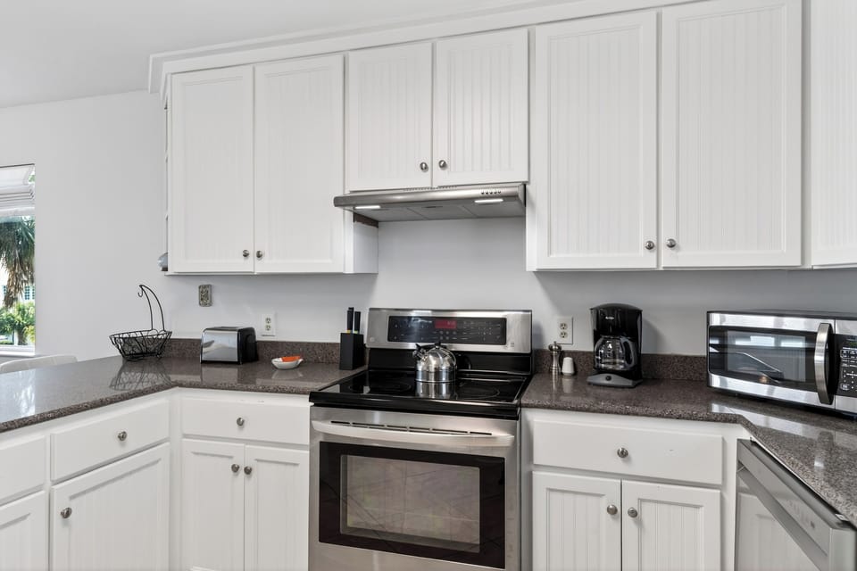 Cook with ease in the clean, coastal kitchen—full-size appliances and plenty of counter space for prep + snacks.