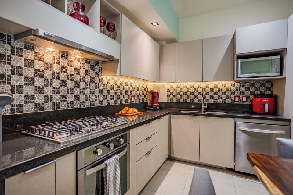 Your fully equipped kitchen features granite countertops, mosaic tile backsplash, and modern appliances perfect for creating memorable meals together.