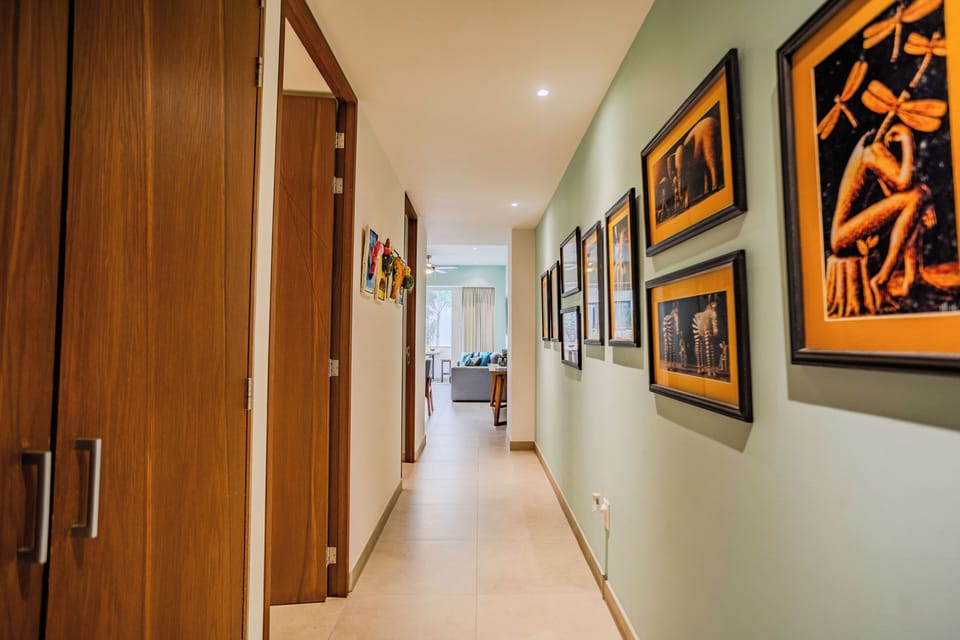 Walk down your thoughtfully curated hallway where warm wooden doors and artistic photographs create a gallery-like experience on your way to relax.