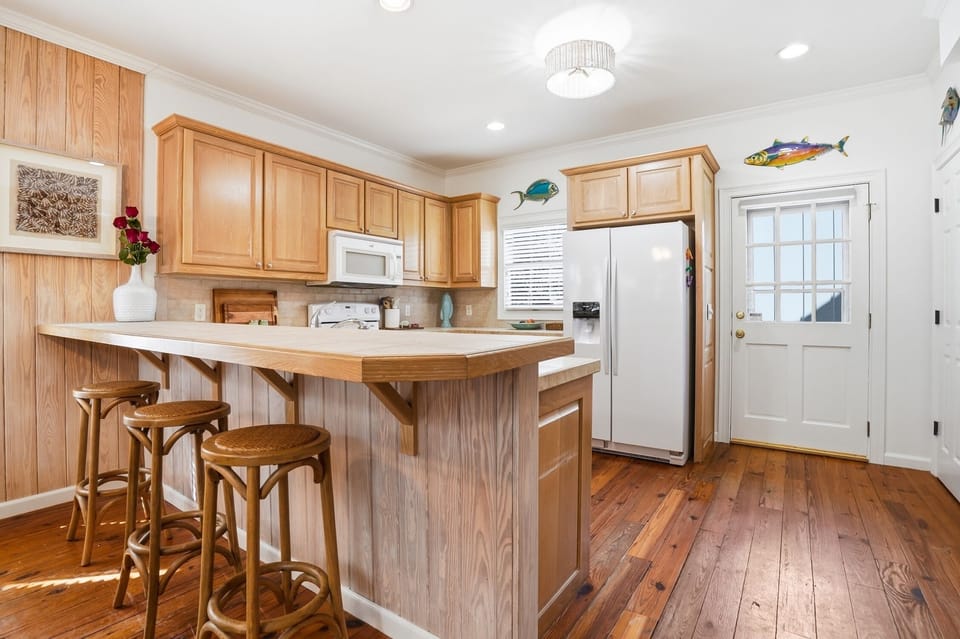 Kitchen Bar and Rear Entry View - Additional kitchen angle showing the breakfast bar, rear entry, and prep space along the main work zone.