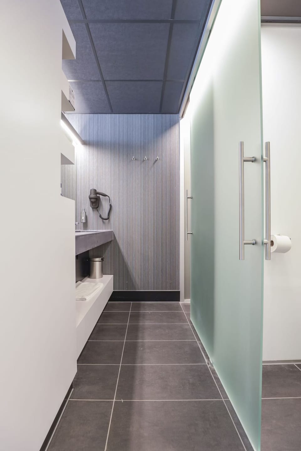 Step into a minimalist bathroom corridor with generous, modern finishes.