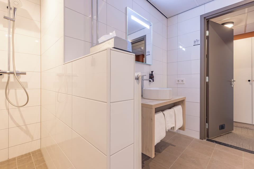 Refresh easily with a bright vanity and sleek walk-in shower.