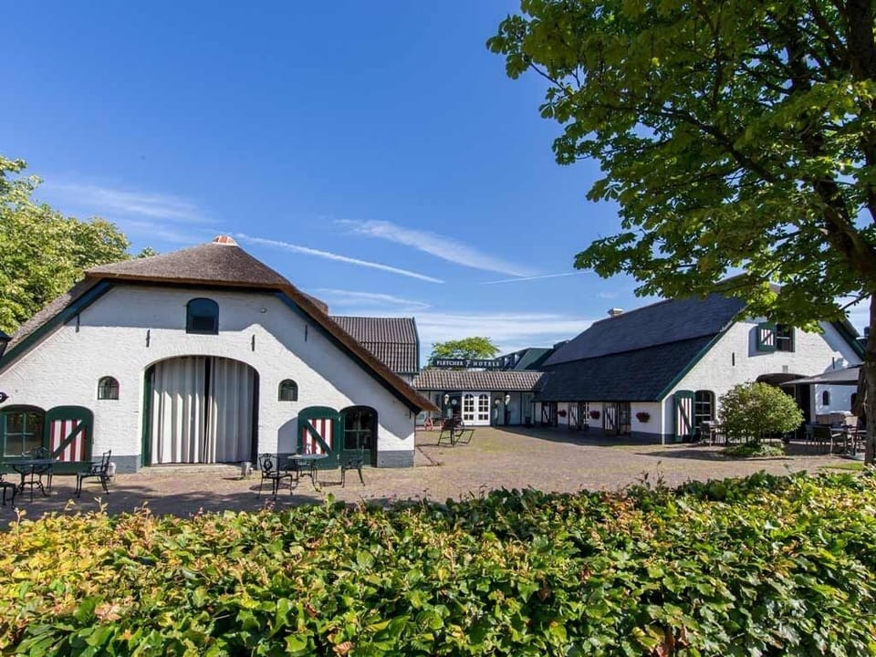 Arrive to a peaceful courtyard framed by charming farm-style buildings.