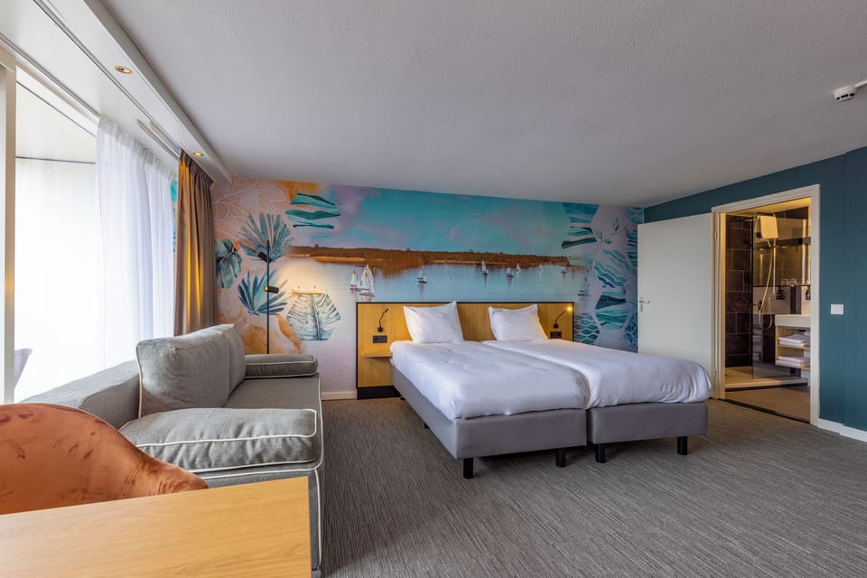 Settle into plush twin beds beside a cozy lounging sofa.