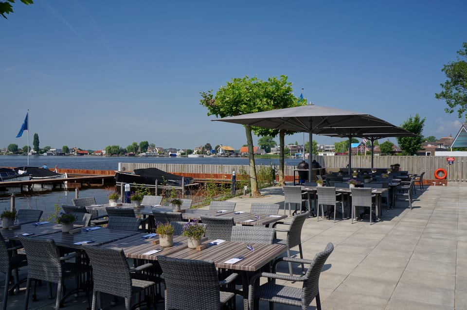 Gather outdoors under shade sails for relaxed waterside dining.