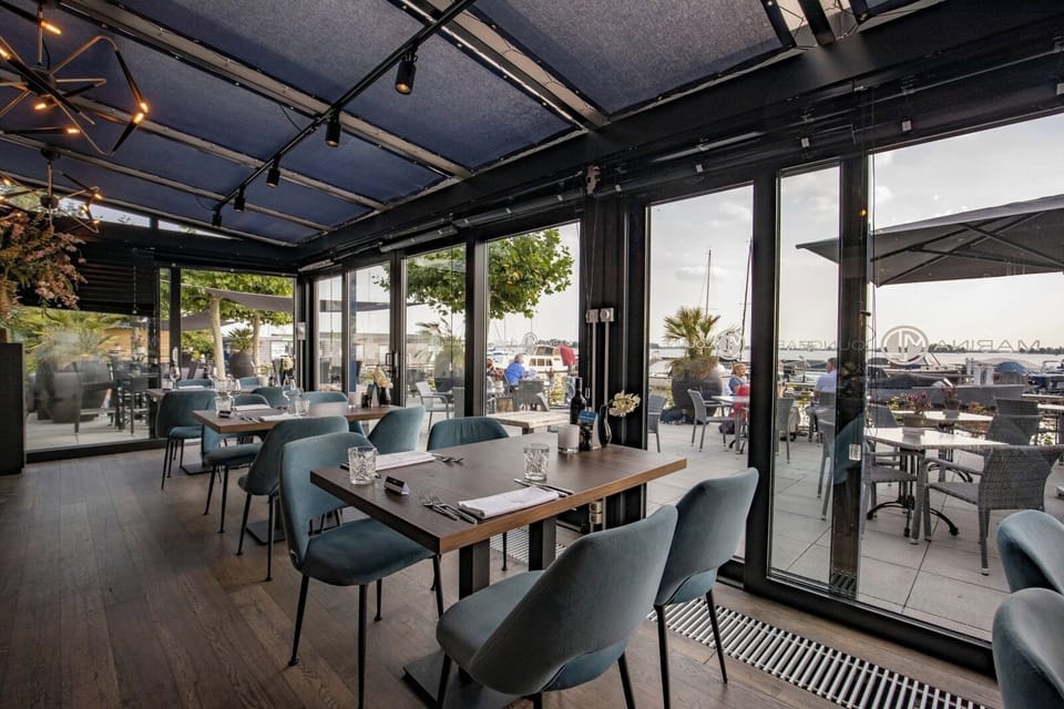 Sip and savor by the windows with marina views outside.