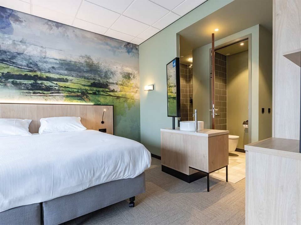 Drift off beneath statement wall art and crisp hotel linens.
