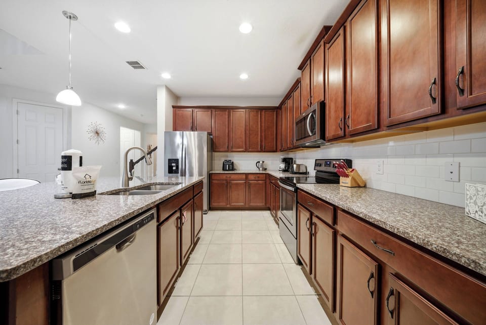 Discover a beautiful kitchen with elegant wooden cabinets and a sleek granite countertop that inspires culinary creativity. The bright lighting enhances the functional layout, making it ideal for meal prep and casual dining.