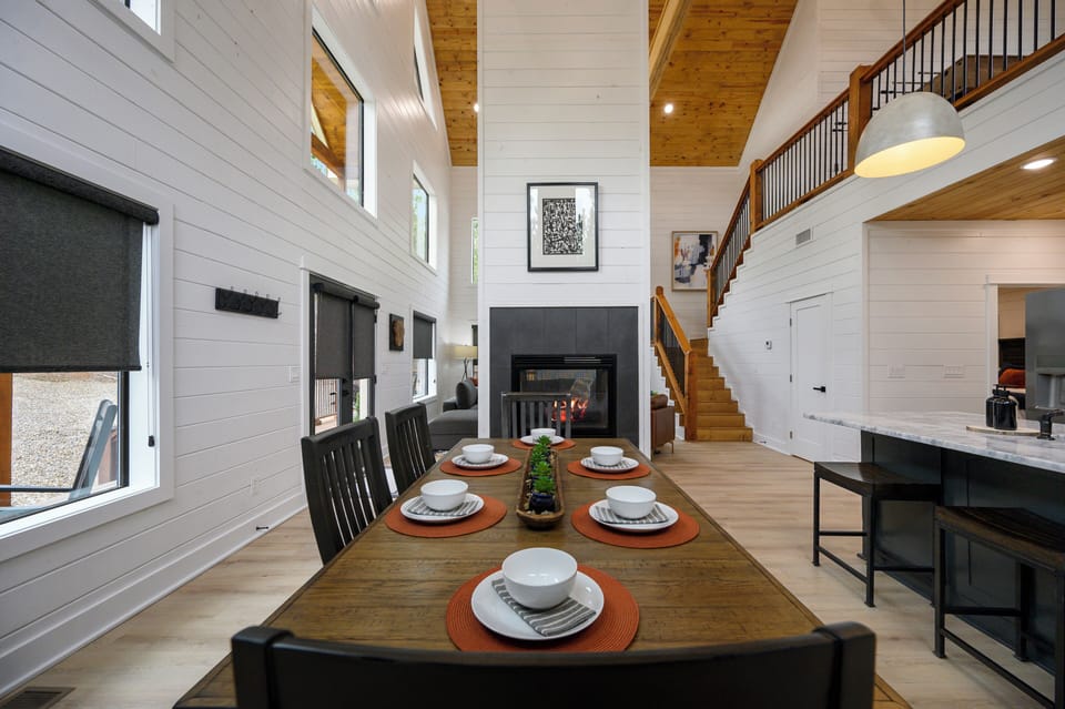 Gather around your rustic dining table while the fireplace crackles, creating perfect moments in this soaring open-concept space.