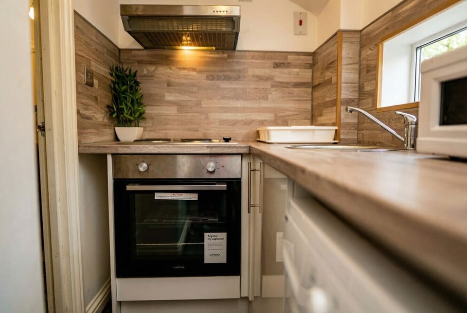 Fully equipped kitchen with oven, hob, and sink for home-cooked meals.