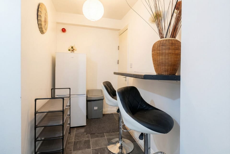 Compact lounge nook with bar stools and a full-size fridge for longer stays.