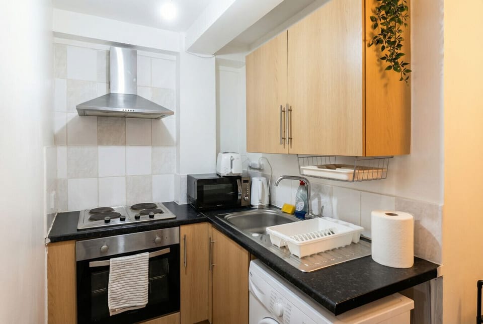 Fully equipped kitchen with oven, microwave, kettle, toaster, and washing machine.
