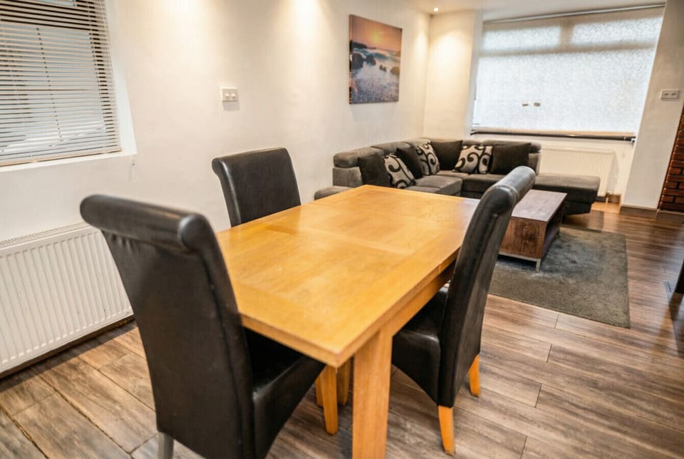 Spacious dining table seats four with a plush corner sofa just steps away.