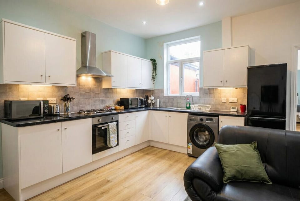 Generous L-shaped kitchen with under-cabinet lighting, gas cooker, and washing machine included.