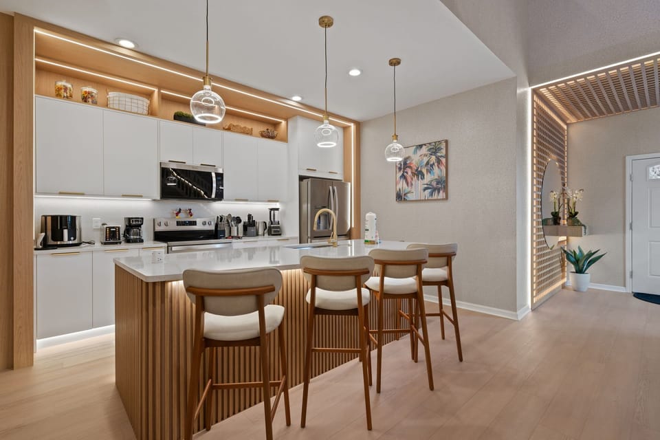 Modern kitchen with island seating and fully equipped appliances.