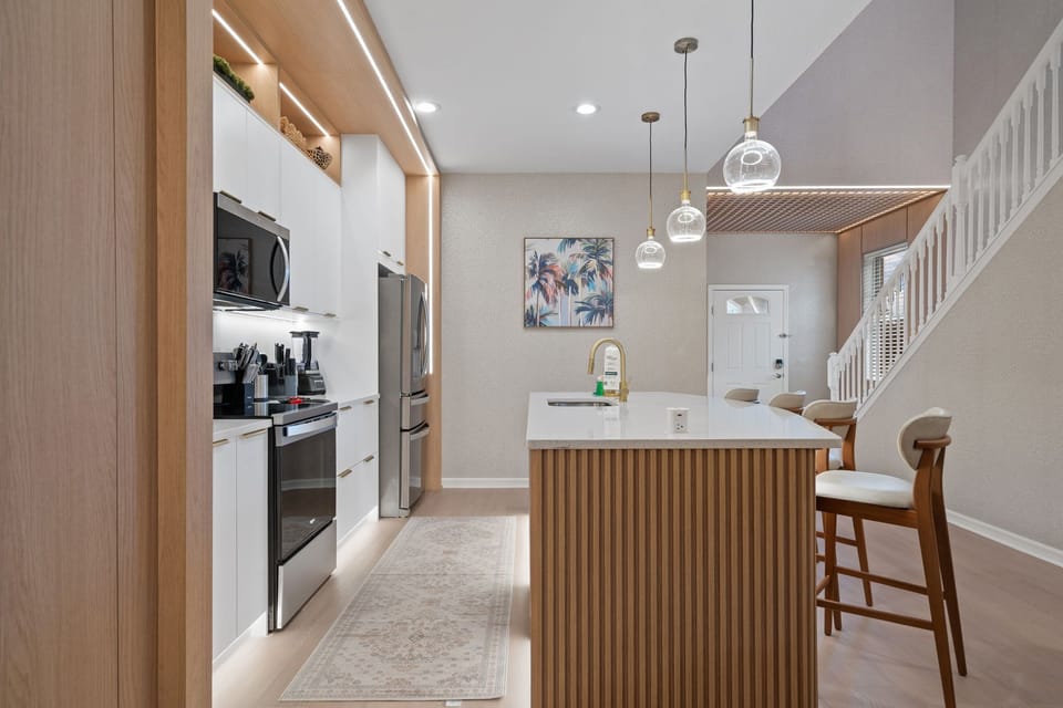 Bright modern kitchen with spacious island and stylish lighting.