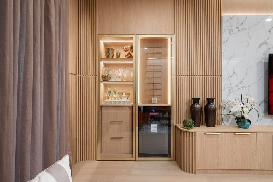 Stylish built-in bar with wine cooler and glassware display.