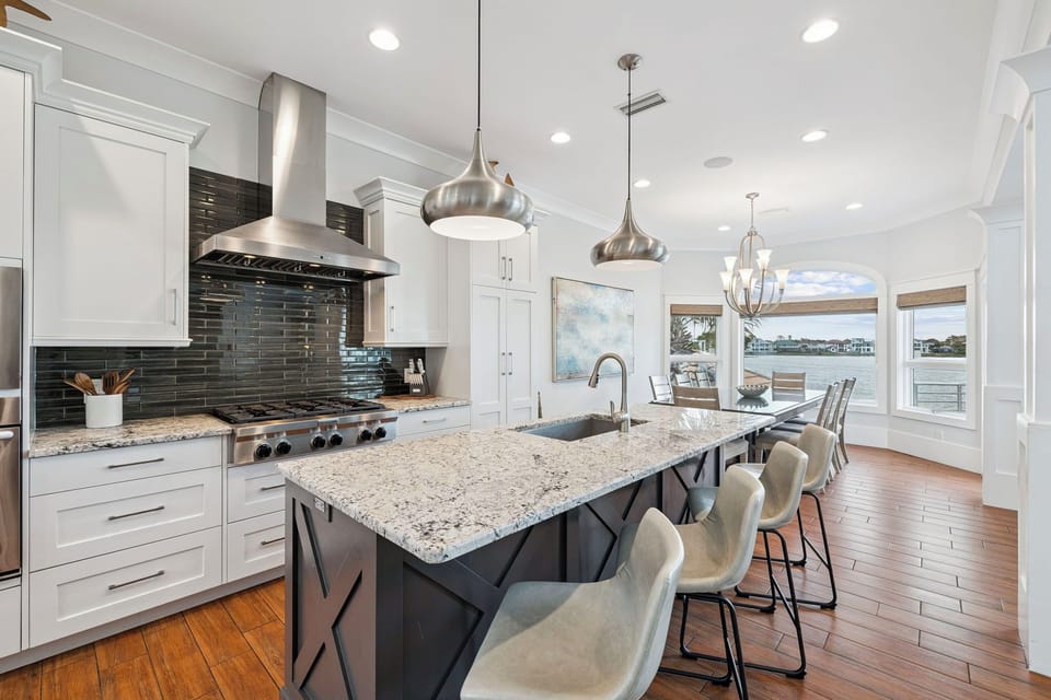 Your gourmet kitchen awaits with granite countertops, stainless steel appliances, and waterfront views through expansive windows.