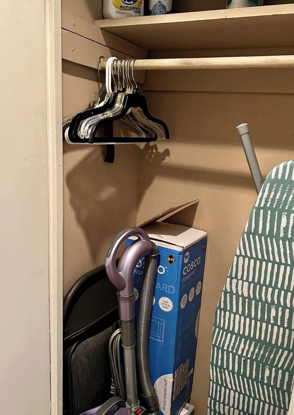Storage with cleaning and ironing supplies.