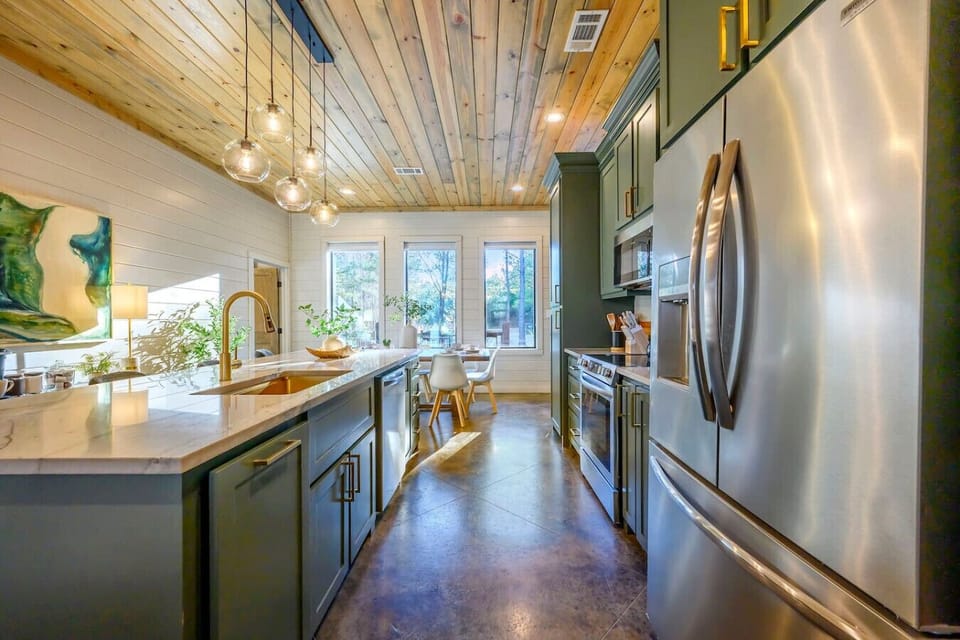 This chef`s kitchen features stainless steel appliances, custom cabinetry, and tons of natural light from those gorgeous windows.