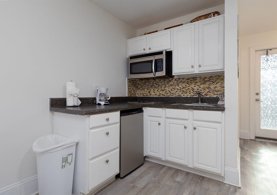 Clean, modern kitchenette with ample cabinet space and essentials for extended stays.