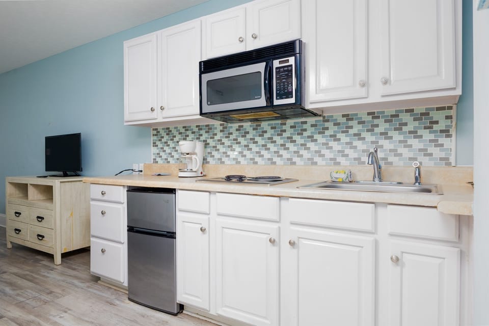 Bright and well-equipped kitchenette with microwave, mini fridge, and coffee maker, perfect for easy meals and relaxed mornings 