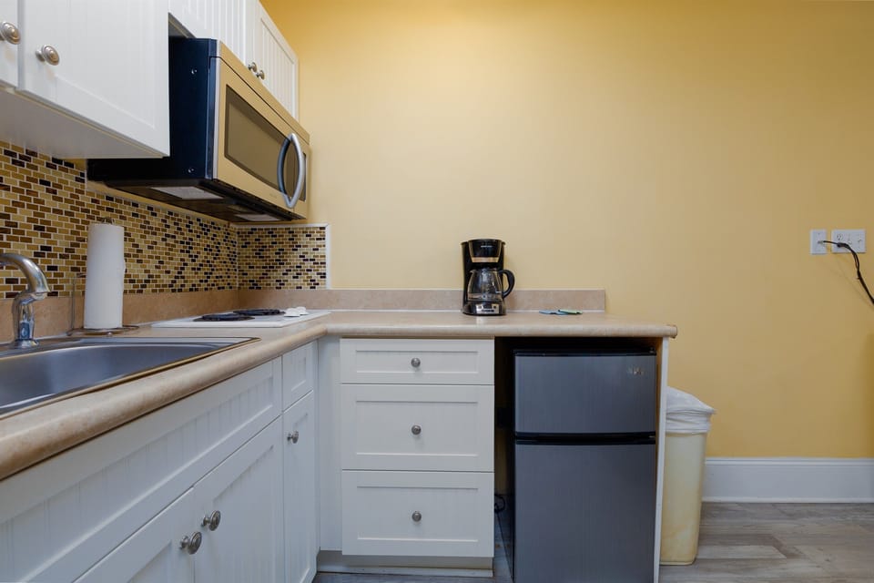 Convenient kitchenette with a microwave, mini fridge, sink, and coffee maker for quick meals