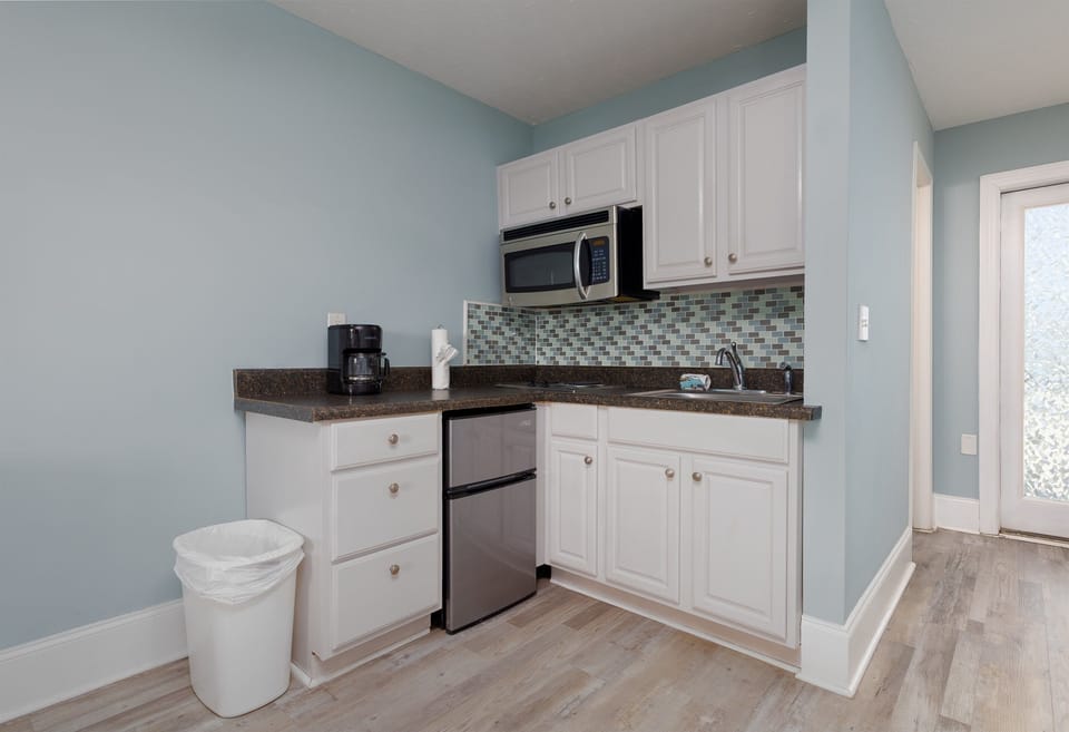 Compact kitchenette with fridge, microwave, sink, and coffee maker; easy setup for simple meals and snacks