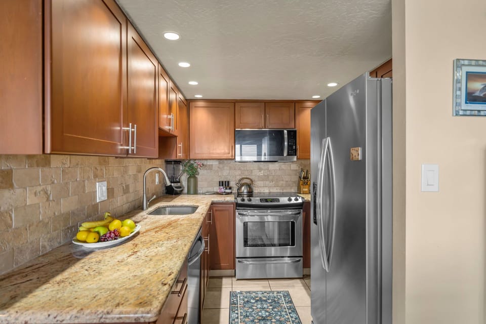 A fully equipped modern kitchen with stainless‑steel appliances, and granite countertops